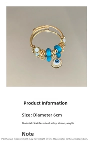 Detail of adjustable evil eye bracelet with blue glass beads and gold finish charms