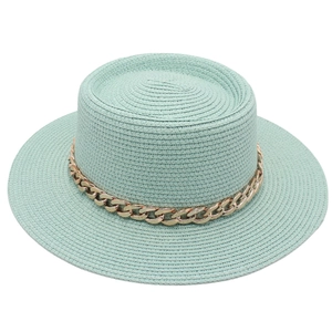 Detail of light mint green straw boater hat featuring a chunky gold chain accent