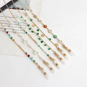 Detailed view of golden eyewear chains with colorful floral and heart-shaped charms