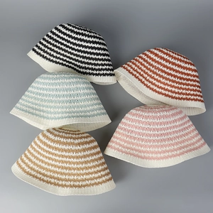 Close-up of knit striped bucket hats showing textured patterns and breathable hollow details