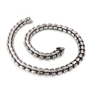 Polished silver dragon scale bone chain necklace with metallic finish on white background