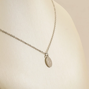 Polished silver stainless steel oval pendant necklace featuring engraved letter C