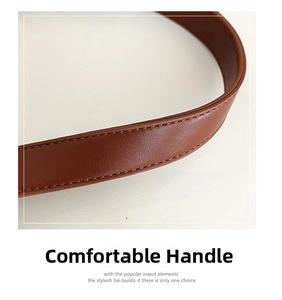 Detail of a brown leather shoulder strap with visible natural texture and fine stitching