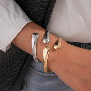 Irregular smooth oval open cuff bracelet in polished gold and silver finishes