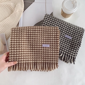 Close-up of wool blended houndstooth scarves with tassels in coffee and black colors