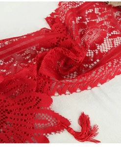 Close-up of red lace Christmas table runner with knitted patterns and tassel detail