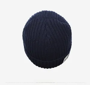 Top view of navy blue ribbed knit beanie featuring thick thermal fleece lining and logo patch