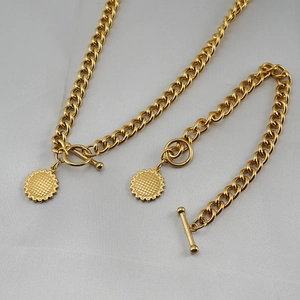 Detailed view of golden Cuban link jewelry set with OT toggle clasp and sunflower charm