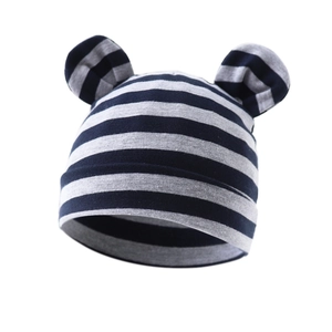 Detail of blue and gray striped baby knit hat with cute bear ears on white background