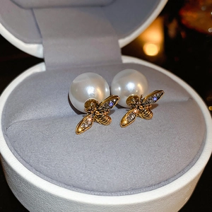 Detail of bee earrings with pearls and crystal inlay on a minimalist jewelry box