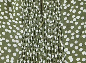 Détail de la robe verte à pois avec smocks élastiques et fermeture éclair invisible