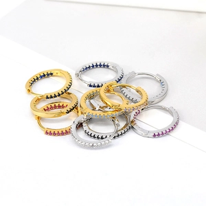 Macro shot of colorful zircon stones on gold and silver hoop earrings in stack