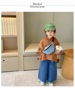 Close-up of a child wearing a blue denim crossbody bag with an adjustable black strap