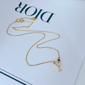 Detailed close-up of a gold cocktail glass pendant necklace featuring zircon stones