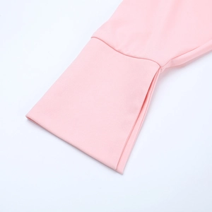 Detail eines rosa Langarmkleids mit plissierten Rüschenmanschetten und weichem Stoff