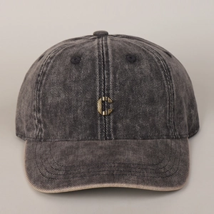 Detailed view of metal C letter emblem on washed cotton vintage baseball cap