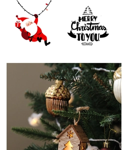 Detail of glowing wooden house and brown acorn ornaments on a Christmas tree