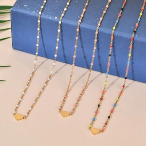 Vue détaillée de colliers de perles colorées avec pendentifs cœur doré sur boîte