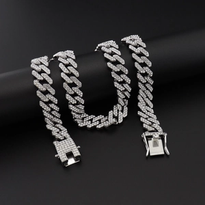 Macro shot of silver hip-hop Cuban link necklace with sparkling crystals on black display