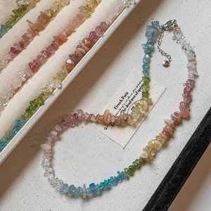 Colorful irregular bead necklaces with natural stones arranged on a beige display tray