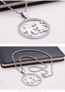 Vue macro d'un pendentif argenté orné de cristaux avec silhouettes de garçon et fille