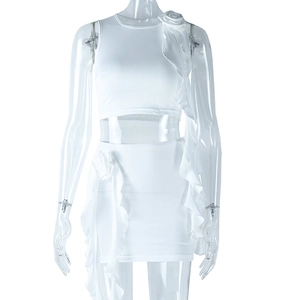Detail of white two-piece set featuring 3D handmade flowers and ruffled mini skirt