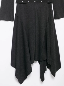 Détail de la robe midi en tricot gris foncé avec boucle argentée et ourlet asymétrique