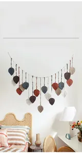 Detail showing colorful macrame leaf tassels on woven wall hanging for home decor