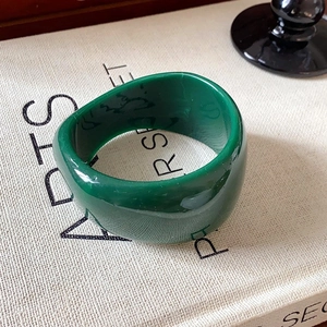 Minimalist emerald green wide resin ring featuring a smooth translucent polished finish