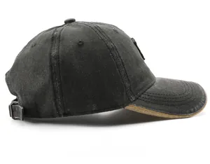 Detail of black baseball cap showing metal buckle adjustment and contrast brim edge