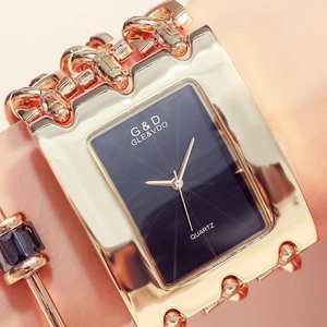 Close-up of golden square quartz watch and matching bracelet on a female wrist