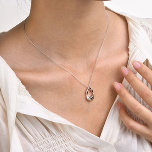 Polished silver irregular pendant necklace on model with white shirt background