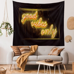Detail showing 'good vibes only' neon typography on black tapestry above a modern sofa