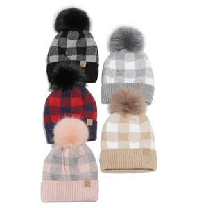 Five assorted winter knit beanies with buffalo plaid patterns and faux fur pom-poms