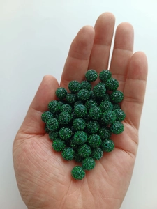Close-up of hand holding a 10mm emerald green clay pave crystal disco ball bead