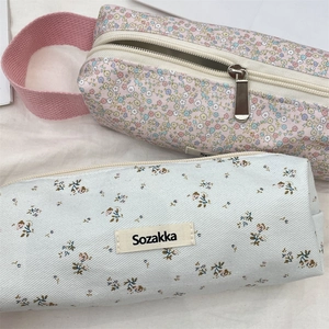 Close-up of floral canvas pencil cases with smooth zippers and sturdy fabric handles