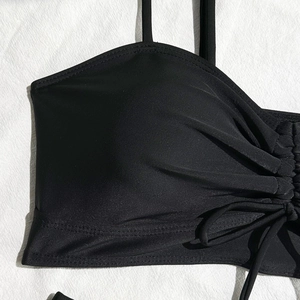 Detail of black bikini top featuring ruching design and adjustable side drawstrings
