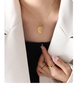 Detail of gold rectangular tarot pendant necklace with relief gesture and moon motif