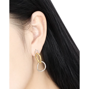 Interlocking geometric triple ring earrings in gold and silver finish worn by a model