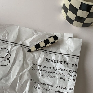 Detail of checkered acrylic hair clip on vintage paper with minimalist ins style