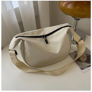 Detail of minimalist cream oxford fabric crescent bag with black zipper and wide strap