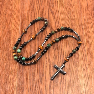 Long beaded cross necklace with tiger eye stones and turquoise beads on wood background
