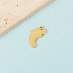 Polished gold stainless steel baby feet charm on light blue background with stone