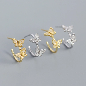 Detailansicht der Schmetterling-Ohrstecker in Silber und Gold mit funkelnden Zirkonia