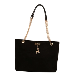Sac bandoulière en daim noir avec chaîne dorée et charm cerf sur un fond blanc épuré
