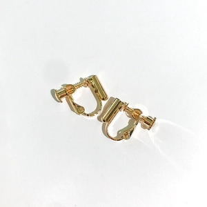Detail of adjustable golden screw-on earring converters for non-pierced ears in gold finish