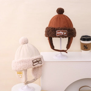 Detail of suede winter trapper hats with plush faux fur lining and Lucky bear patches
