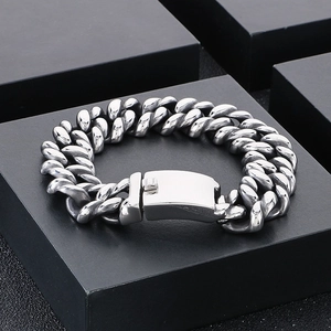 Macro detail of silver stainless steel Cuban link bracelet with industrial push clasp