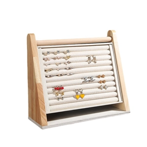 Wooden jewelry display tray with beige velvet slots for rings and earrings