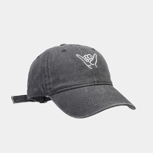 Close-up of a dark grey washed cotton baseball cap with white Shaka hand gesture embroidery